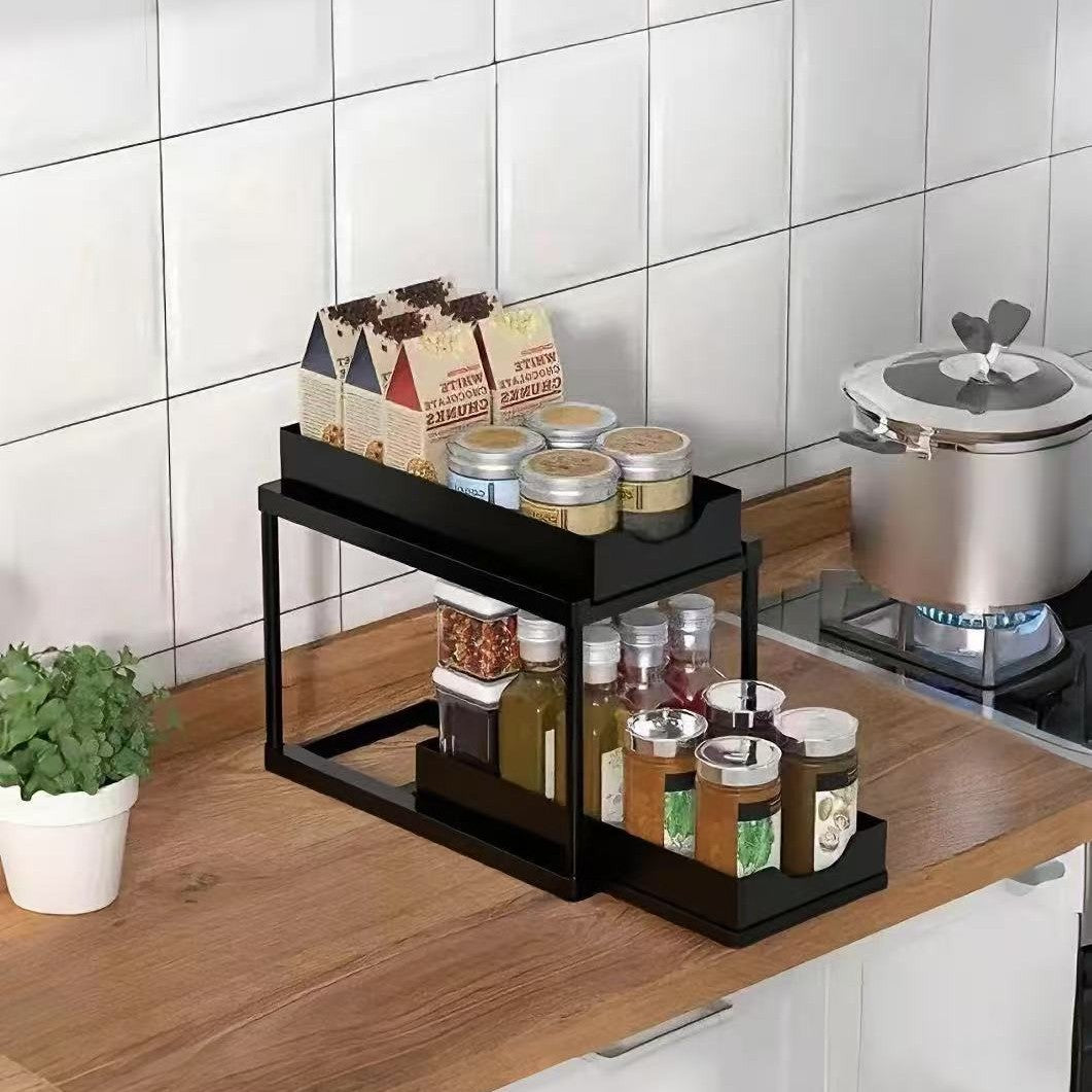 BLACK Two-tier pull-out storage rack. An organizational lifesaver for under the kitchen sink. Features adjustable shelves for easy storage of bottles and jars. In a sleek, modern design. Perfect as a kitchen shelf, bathroom organizer, or household storage